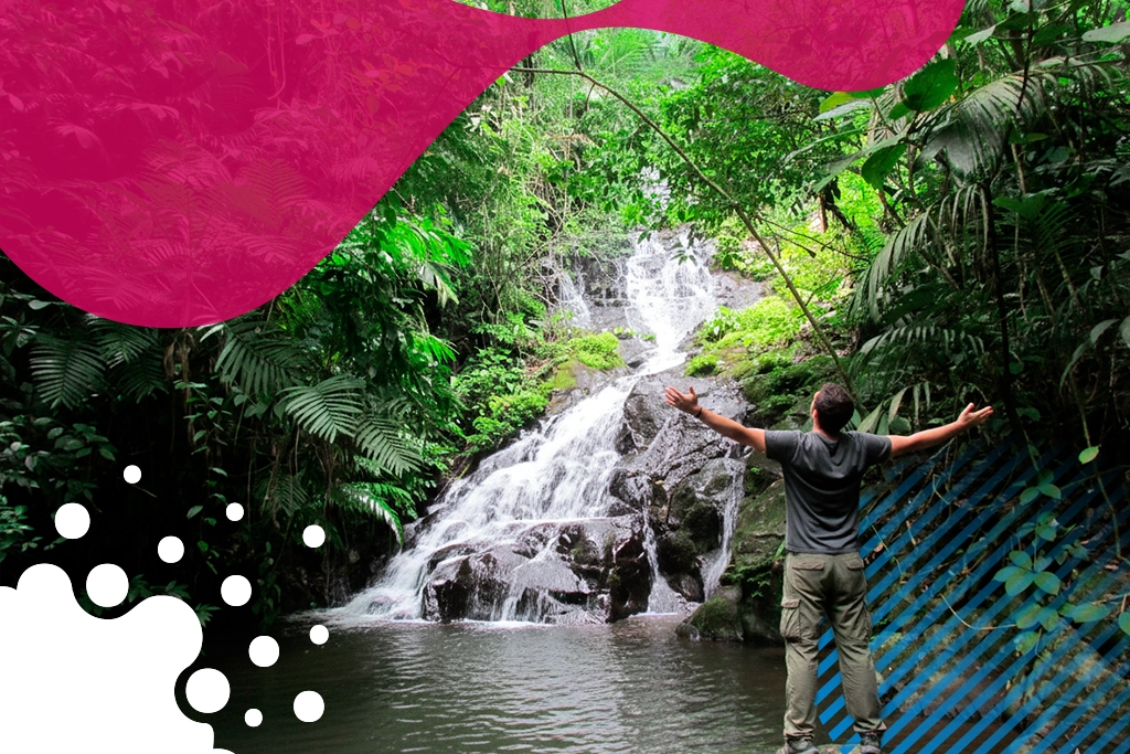 hombre de brazos abiertos frente a cascada | JAPI