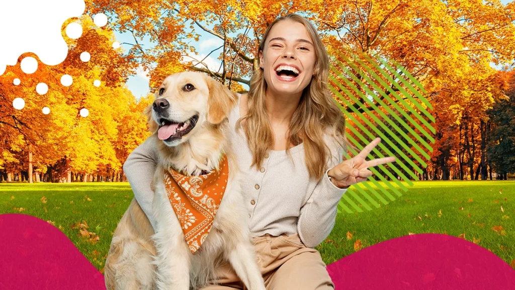 mujer riendo con un perro a su lado