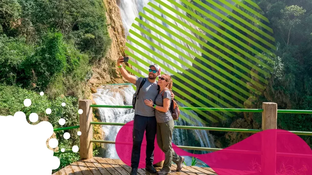 pareja tomándose foto frente a cascada | JAPI