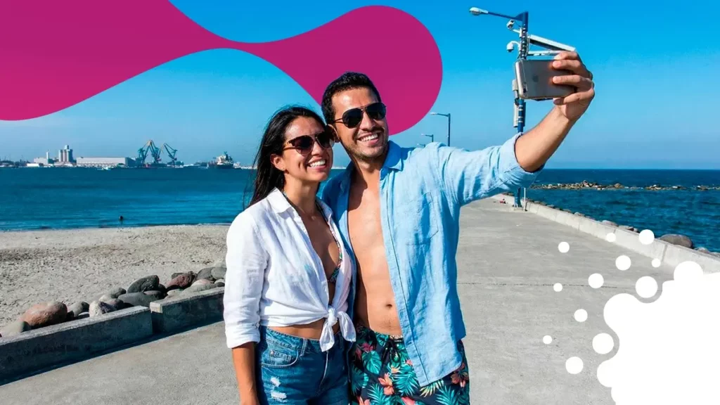 pareja tomándose foto frente a puerto | JAPI